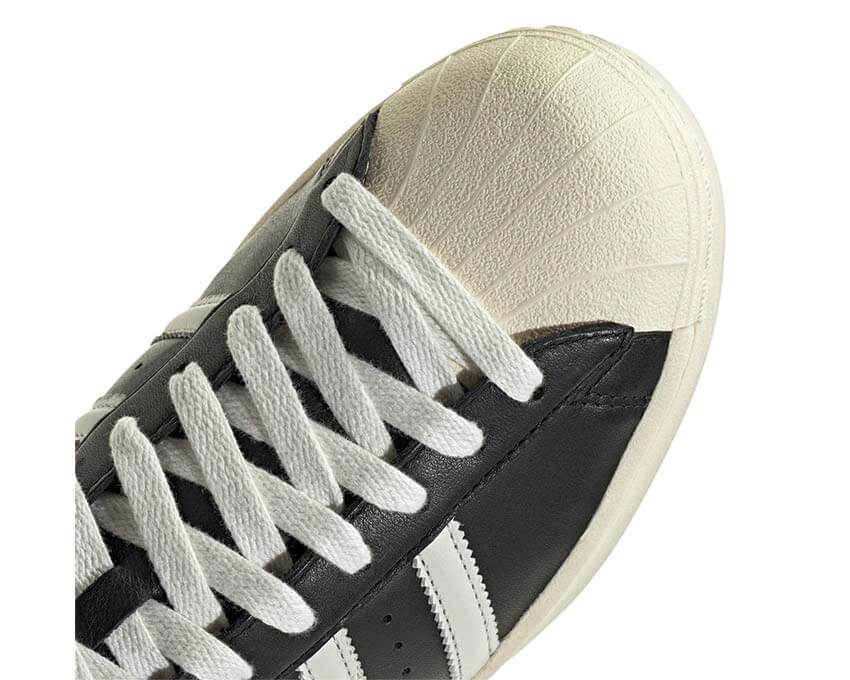 Adidas Superstar Vintage Core Black Cloud White vista lateral — tres bandas clásicas
